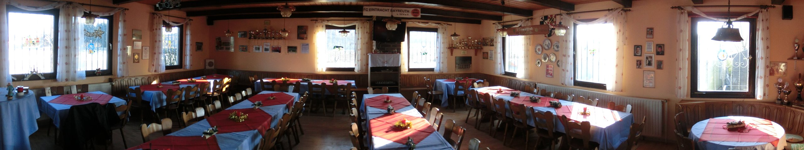 Panoramaaufnahme des gesamten Gastraums mit umlaufender Bestuhlung und gedeckten Tischen